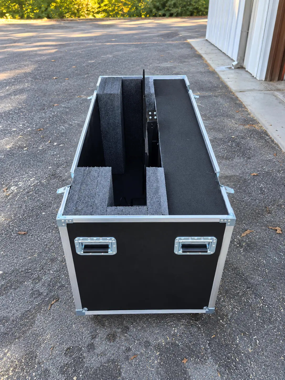Black 51"-60" TV ATA case with electric lift, angled open side view showing internal foam structure and TV mount