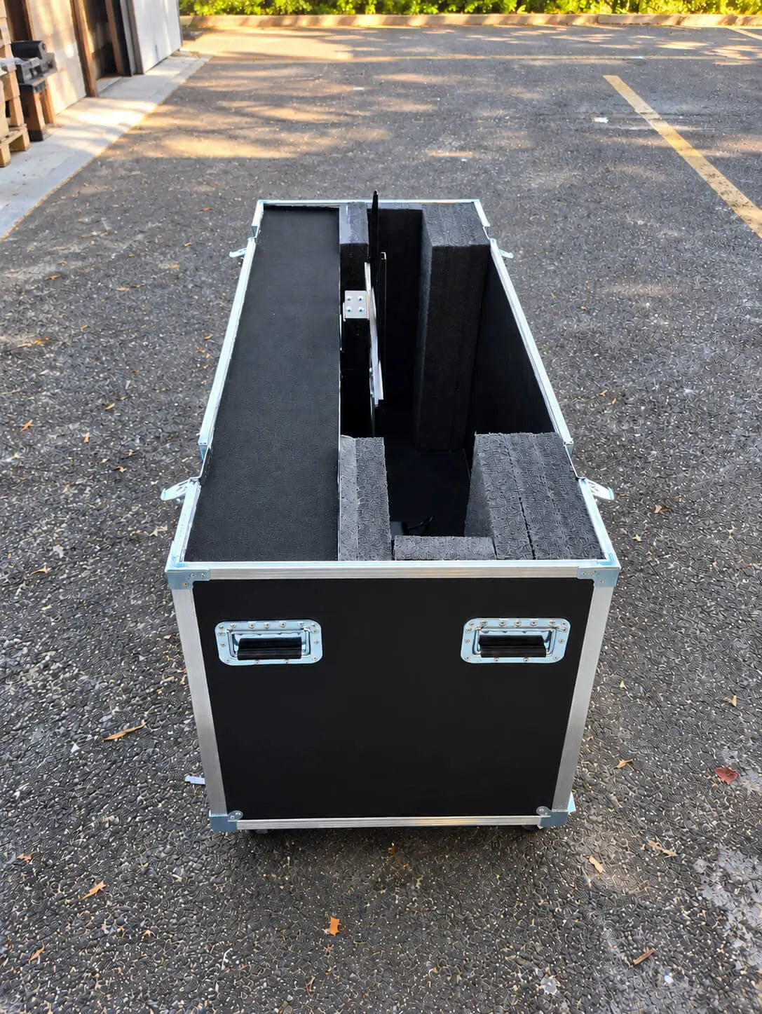 Black 51"-60" TV ATA case with electric lift, open side view showing interior foam compartments and center mechanism