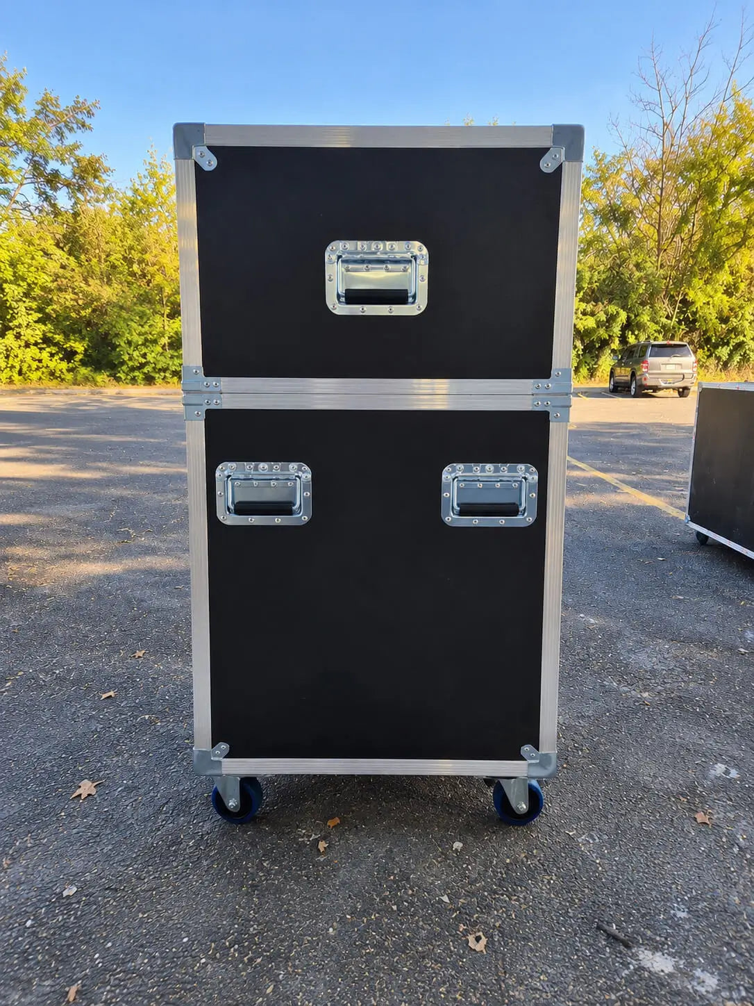 Black 71"-80" TV ATA case with electric lift, closed side view showing recessed handles, latches, and blue casters